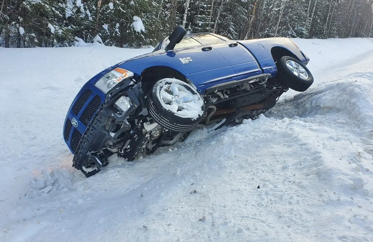 Car in a snowy ditch waiting for a winch-out near Thunder Bay