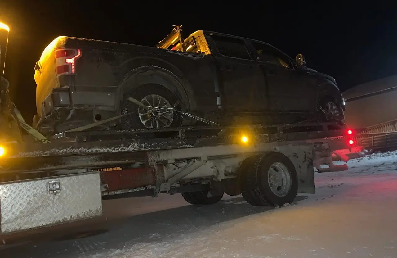 Pickup truck loaded on a Total Towing flatbed at night in Thunder Bay